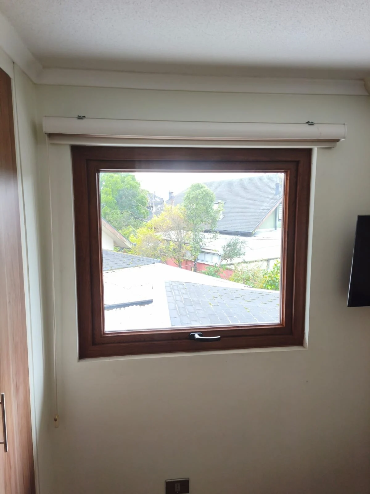 Nueva ventana proyectante de PVC con acabado madera instalada